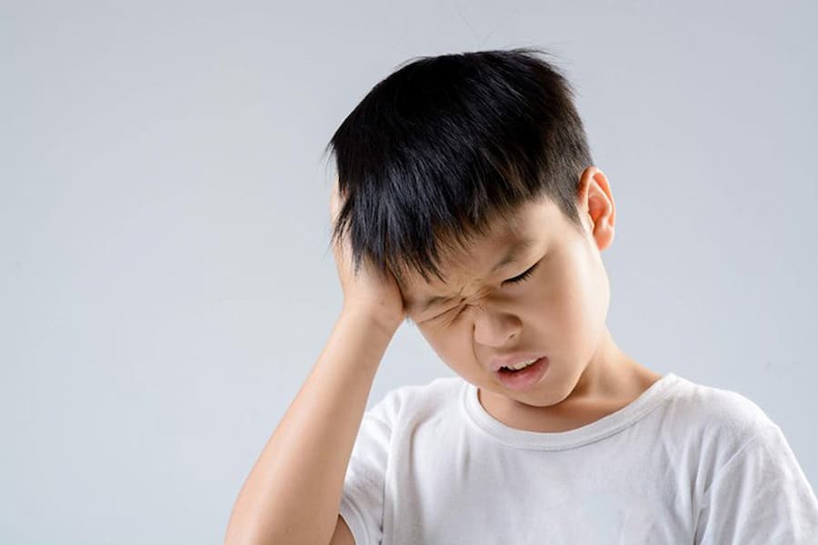 Đau đầu kéo dài là biểu hiện của bệnh lý liên quan hệ thần kinh, cần quan sát và đưa trẻ đi thăm khám sớm. Ảnh: NHC